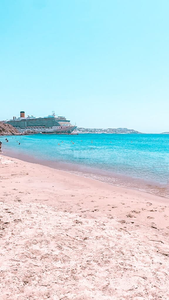 Agios Stefanos Beach Kreuzfahrtschiff im Hintergrund