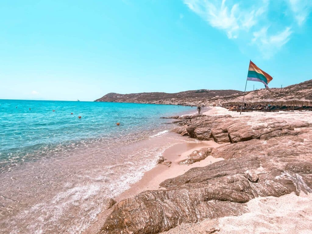 Elia Beach LGBTQ Fahne im Hintergrund