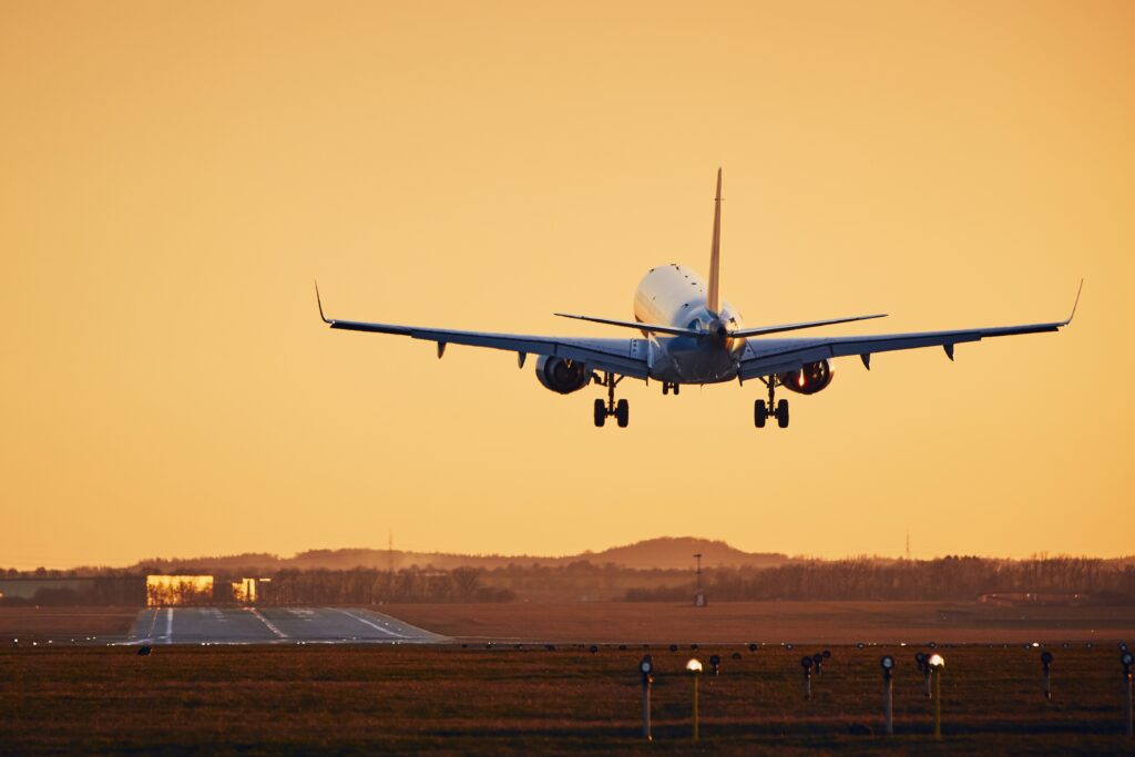 Flugzeug landet gerade am Flughafen bei Sonnenuntergang